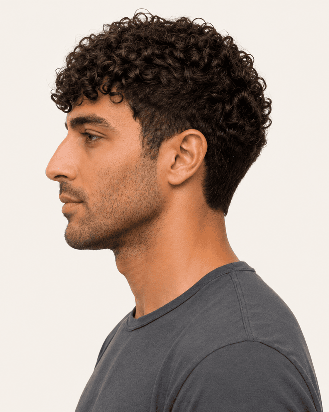 Side profile of a curly fringe crop showing the taper and curl volume