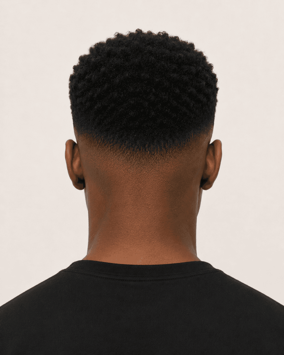 Rear view of a low skin fade with textured top showing the fade wraparound and nape